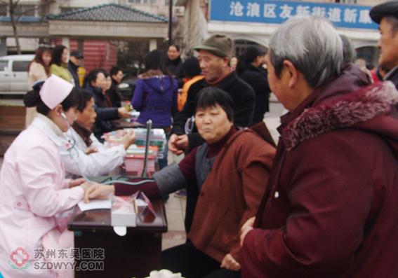 东吴中西医结合医院“ ”医疗志愿者服务队为居民`测血压，解答各种健康方面的问题
