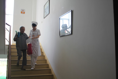 护士搀扶帮助老年人下楼