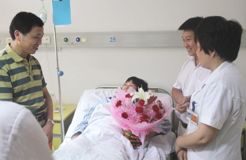 东吴中西医结合医院曾志贤院长（左一）与手术主刀医生谭晓静主任（右一）到病房看望手术后的花女士